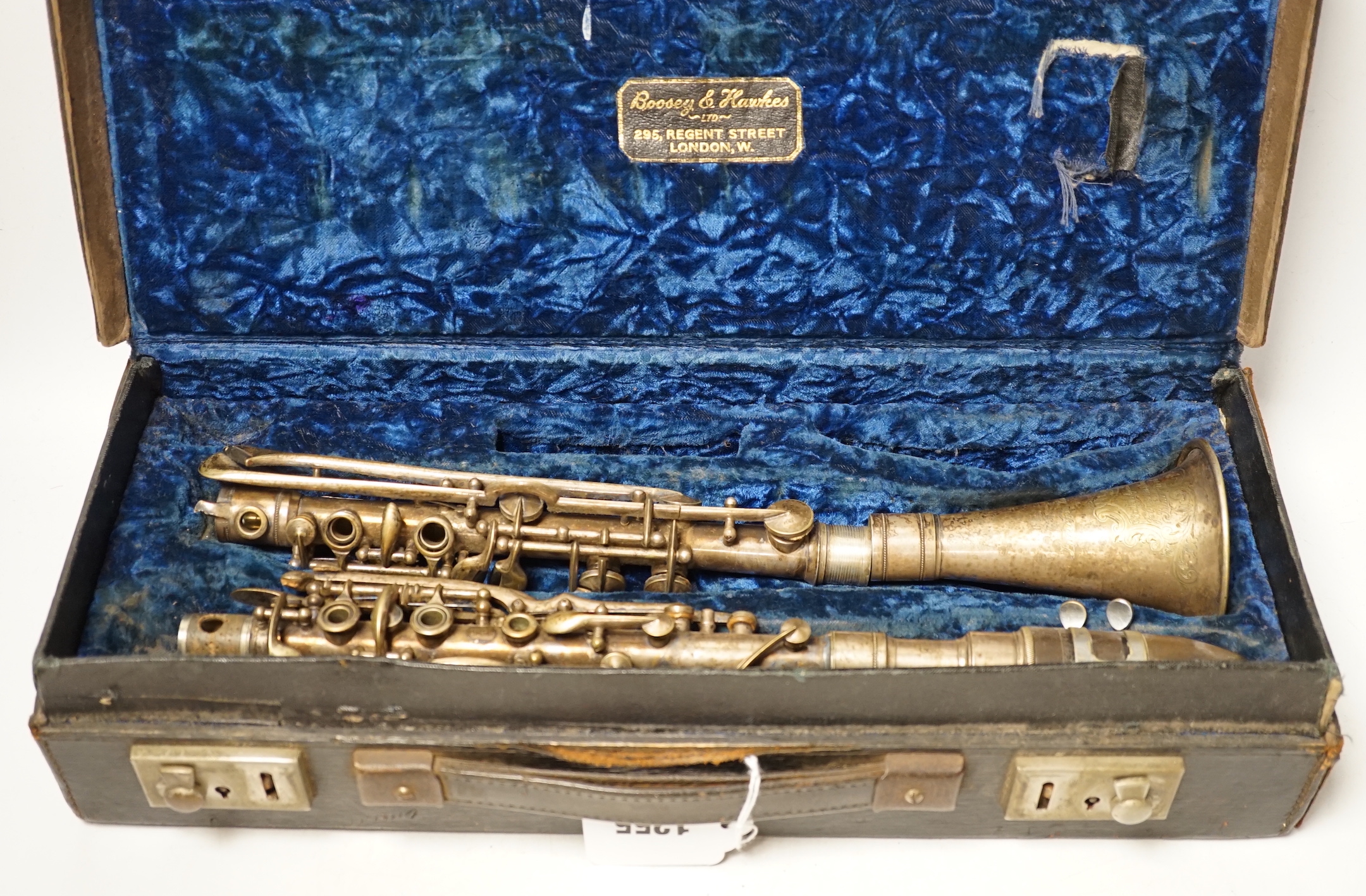 An early 20th century cased Boosey & Hawkes clarinet with plated metal body, bell engraved with ‘Lucian Bassi, British Agents Heywood & Sons, Blackpool’